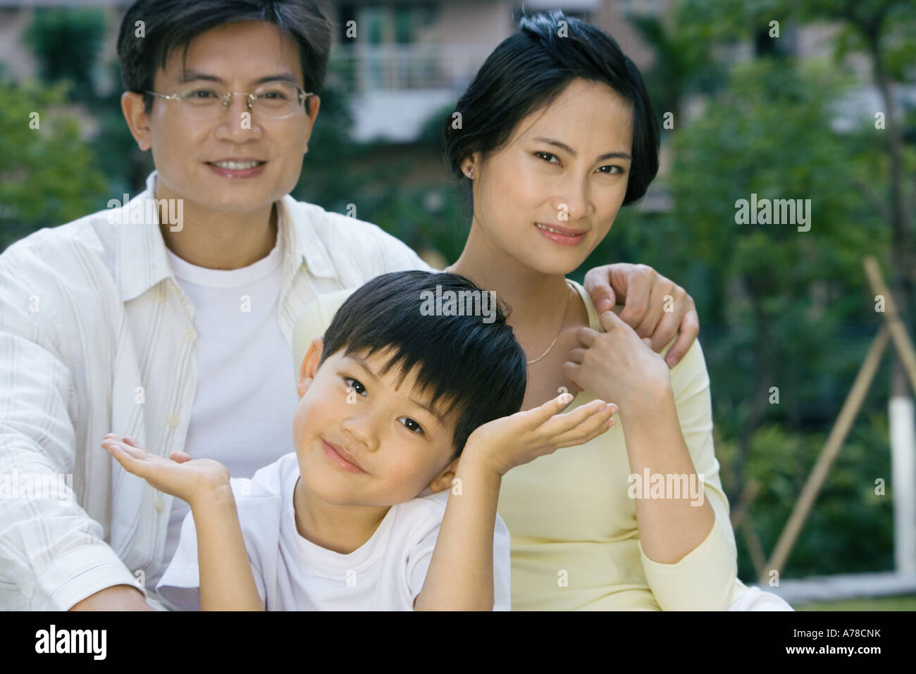 Family, smiling at camera, boy shrugging Stock Photo