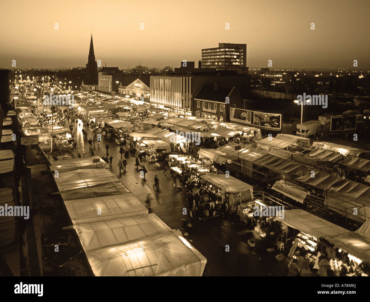 Historical aerial birds eye winter view looking down on urban landscape stalls & shoppers in Romford market place church spire  East London UK Stock Photo