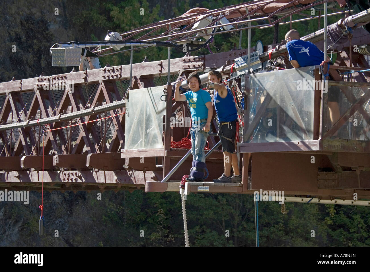 Japanese man waving from platform Kawarau Bridge Bungy Bungee Queenstown South Island New Zealand Stock Photo