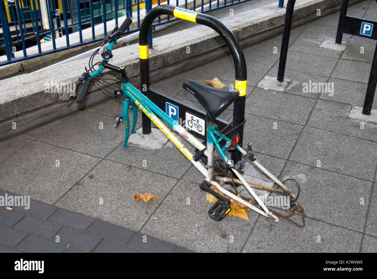 Elephant and Castle area of South London remains of vandalised bike with only main frame padlocked to official parking place Stock Photo