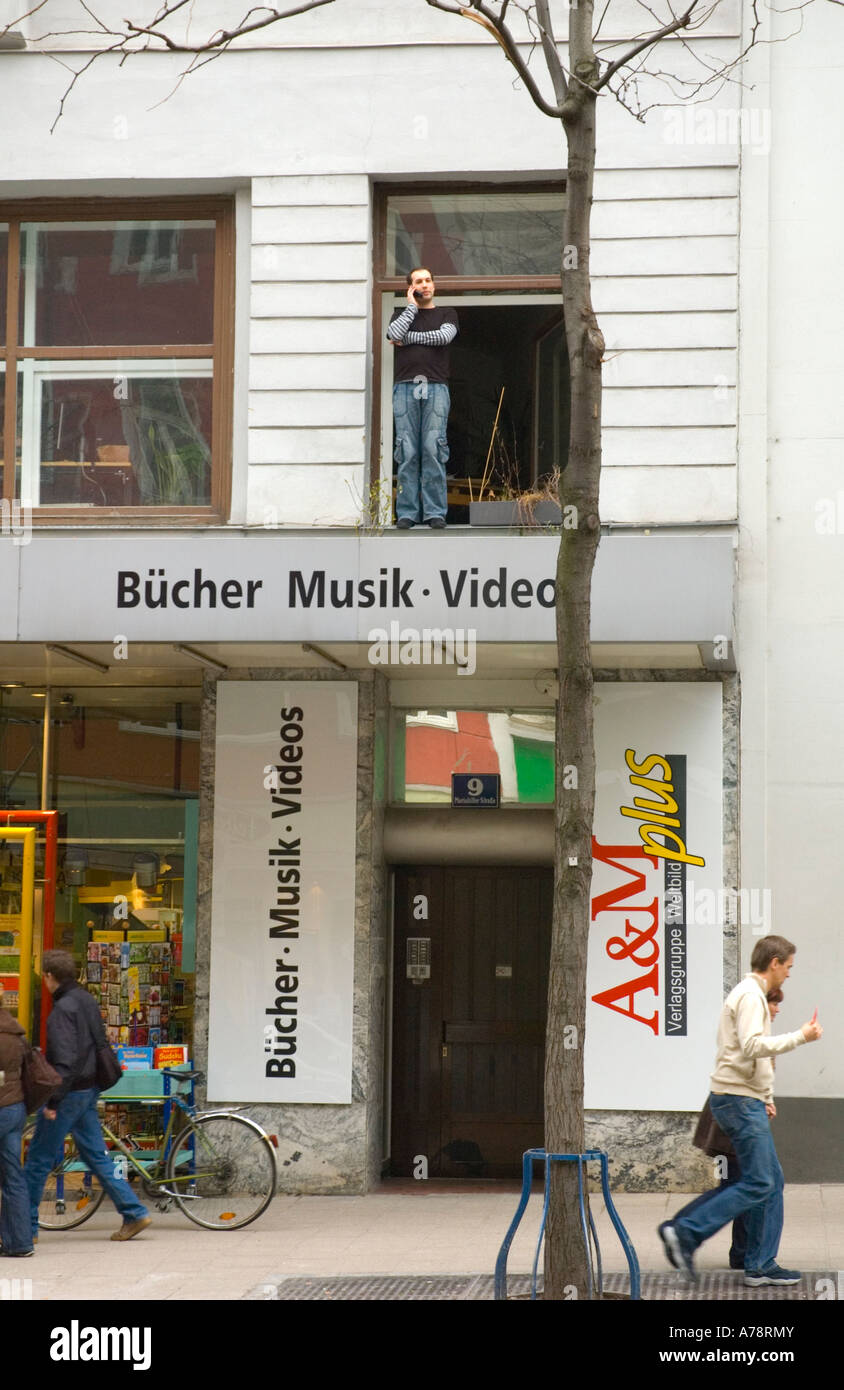 A man talking on mobile on a windowsill along Mariahilferstrasse central Vienna Austria EU Stock Photo