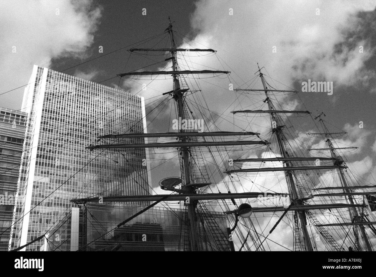 CHRISTIAN RADICH masts, flanked by Docklands skyscrapers in London  Docklands. Monochrome image. Stock Photo