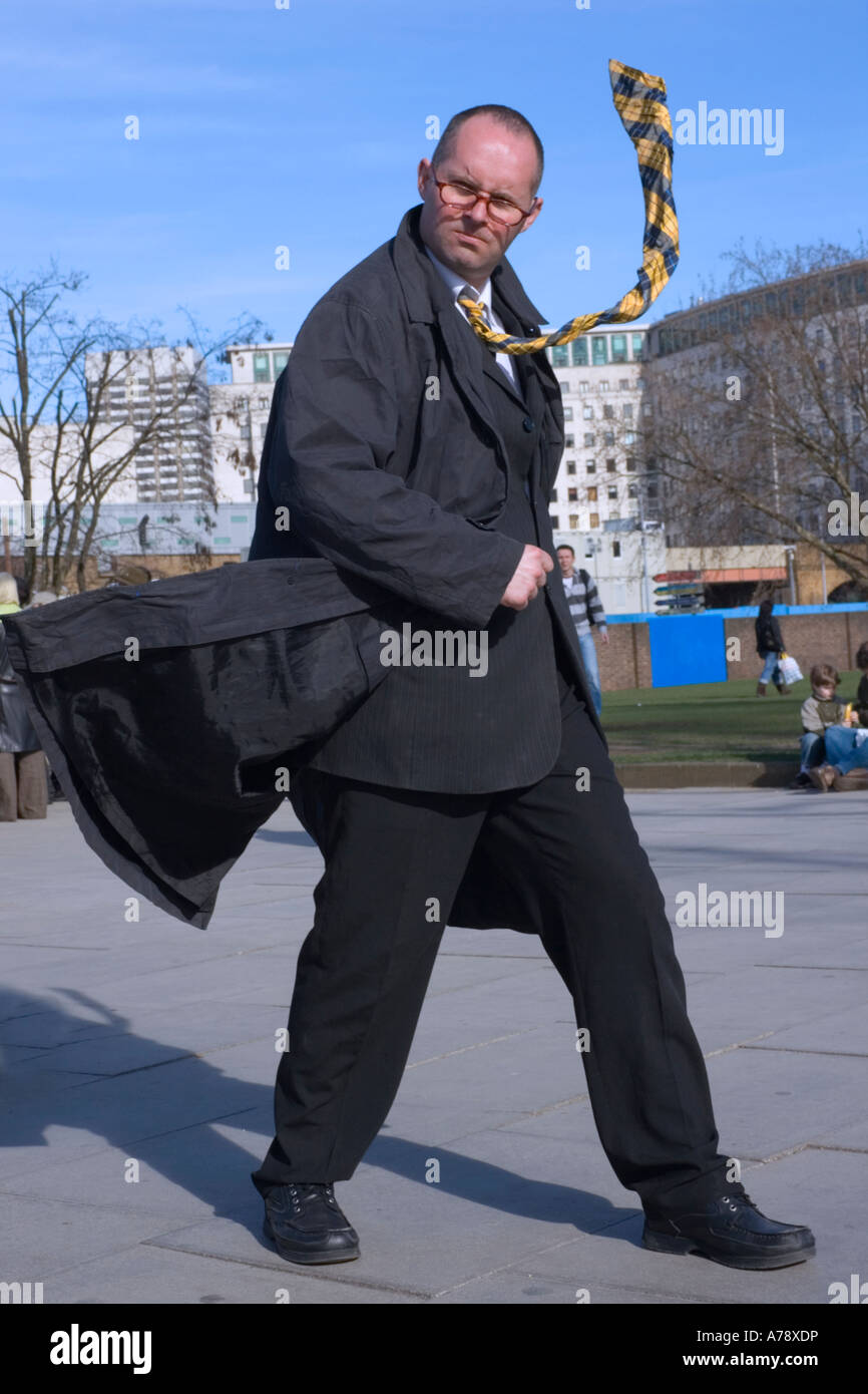 FREEZE FRAME. Busker on South Bank poses with 'trick' clothing, as if caught in the wind. Stock Photo