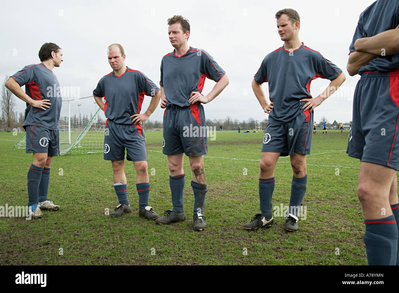 Footballers standing on the pitch Stock Photo