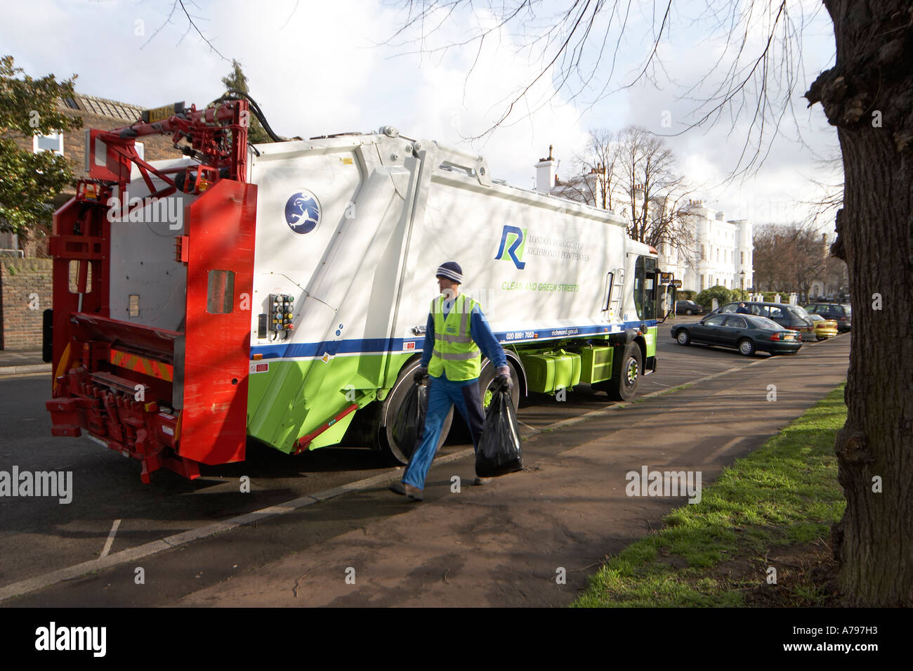 Waste rubbish or trash lorry or truck with man carying black bin bags