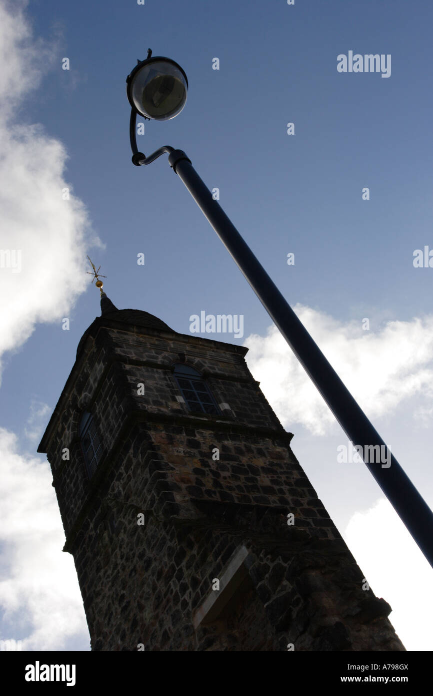 Silhouetted  tower and weathercock of the medieval parish church of St. Mungo with nearby streetlight in Alloa, Clackmannanshire Stock Photo