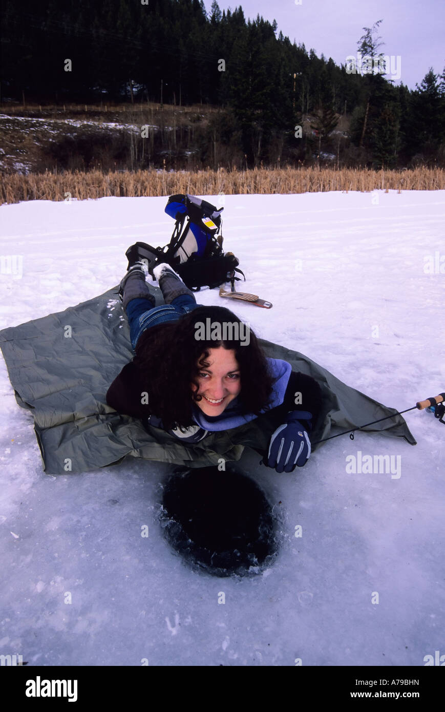 A woman ice fishing near Williams Lake BC Stock Photo Alamy