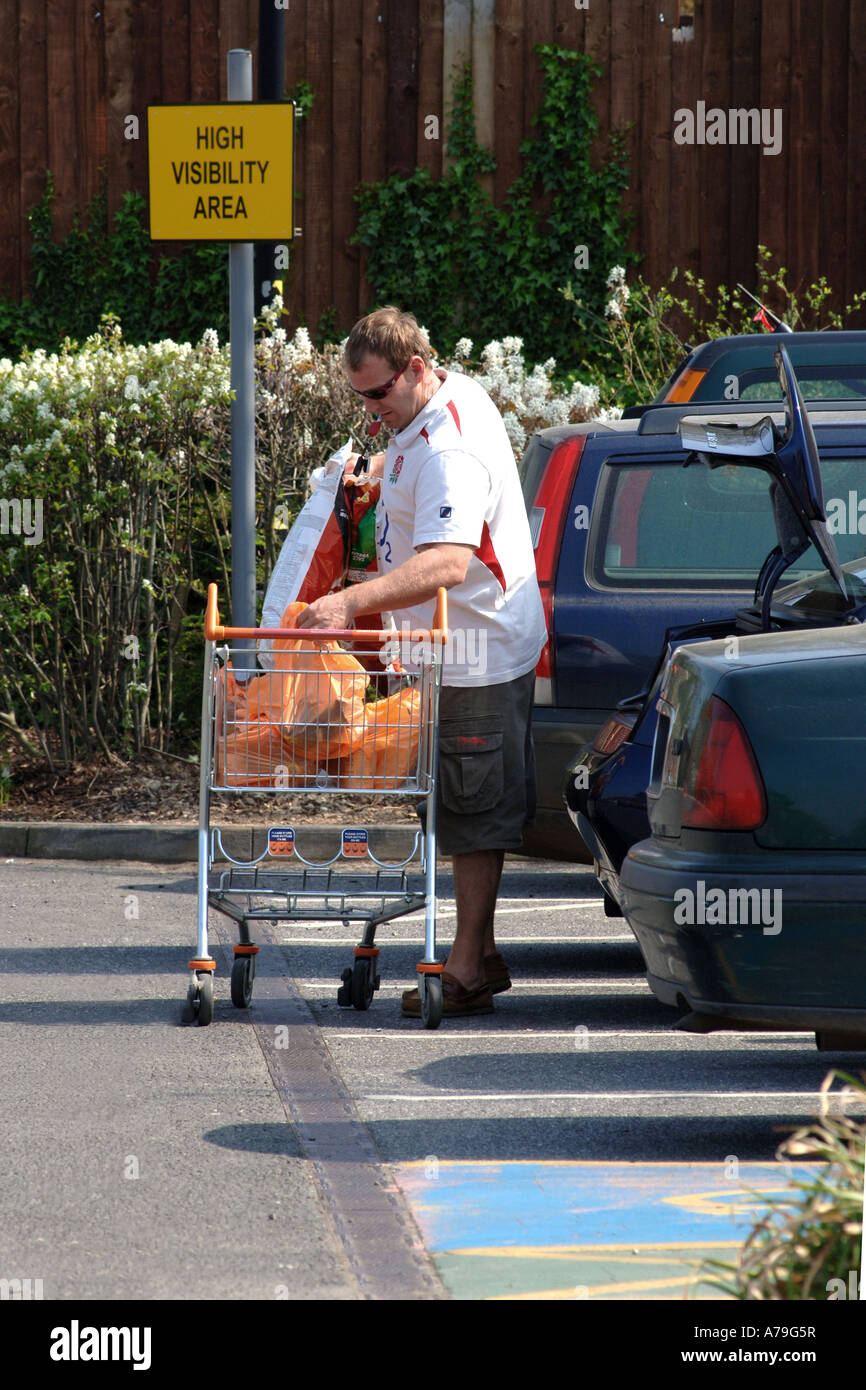 Adult male loading up his car with shopping bags from a cart Stock ...