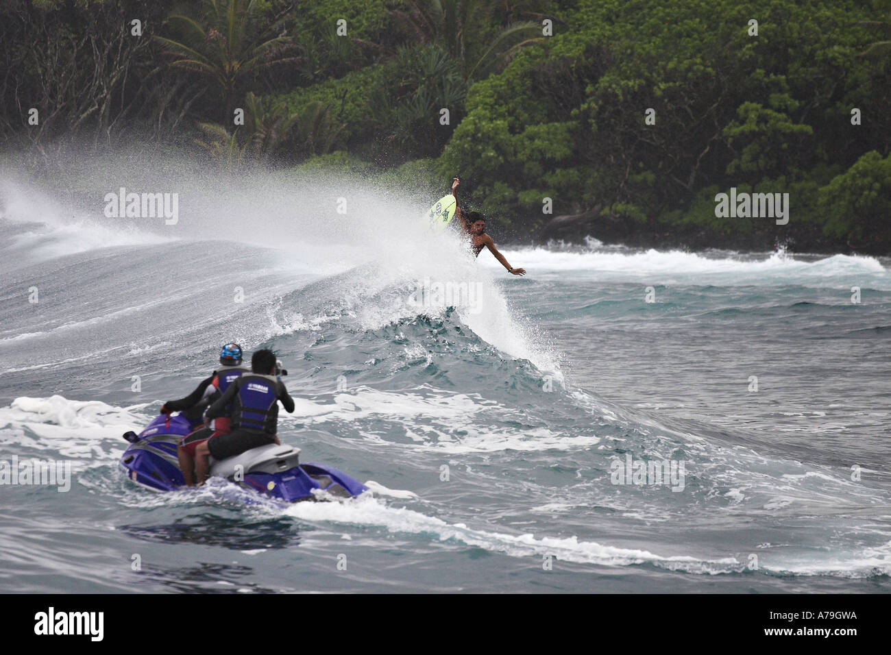 Two people on a seadoo film a male surfer about to flip out on a big wave Isaac Hale Beach Park