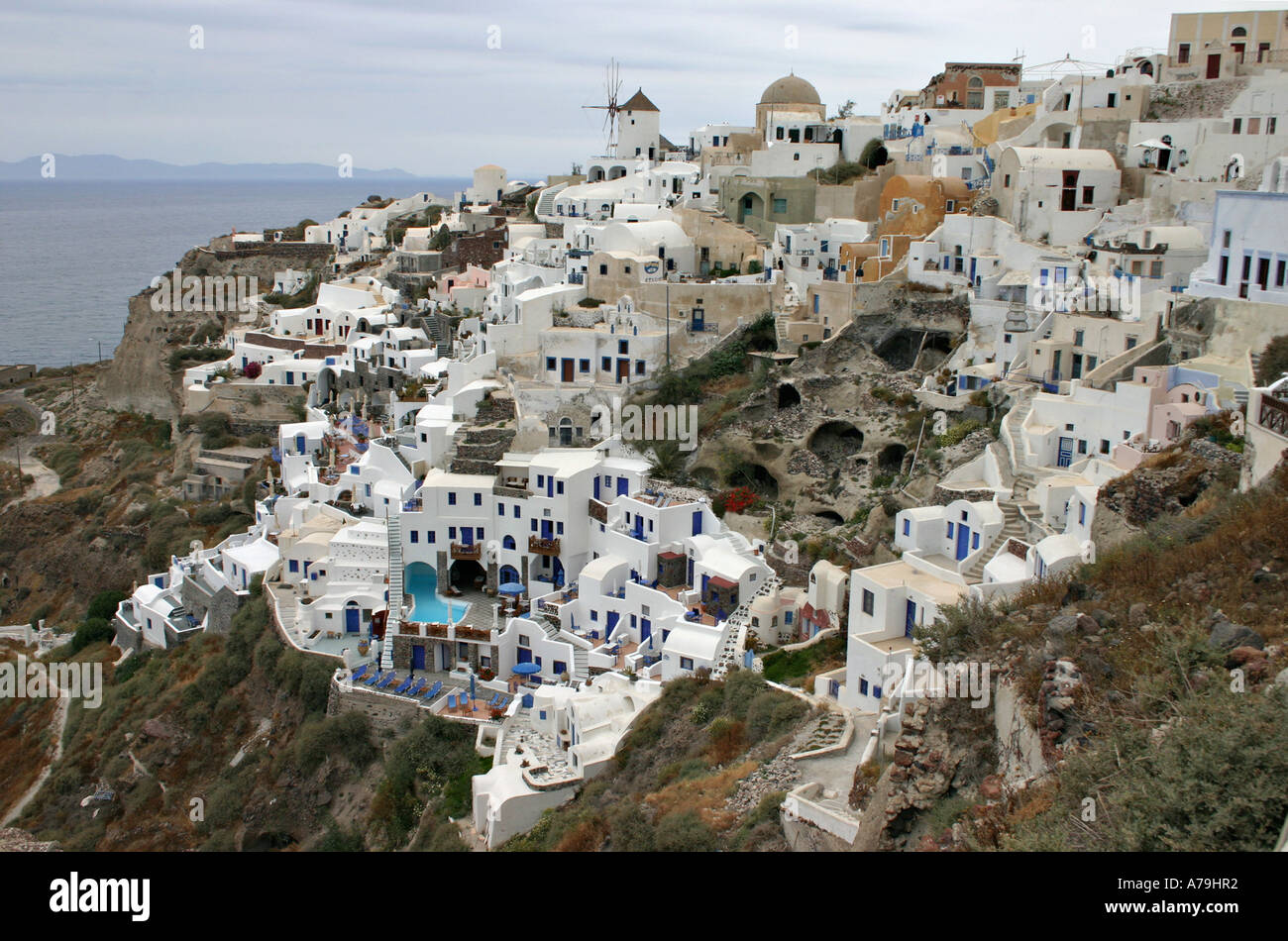 Oia Town: The pastel coloured boxy houses seemingly littered haphazardly spills down the slope of the upper town in Oia Stock Photo