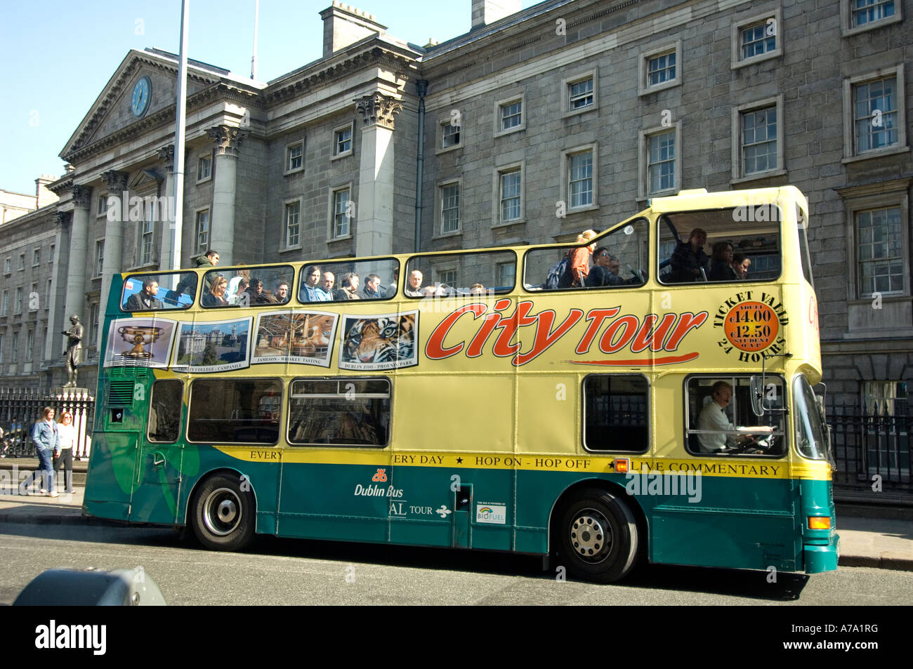 An open-topped tour bus outside Trinity College in Dublin, Ireland Stock Photo