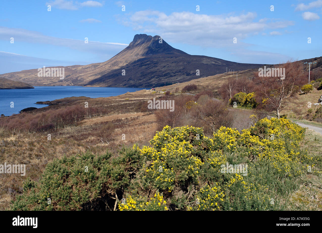Famous Scottish small mountain Stac Pollaidh (612 m) seen from single track road named North Coast 500 along Loch Lurgainn in Highland Scotlland Stock Photo