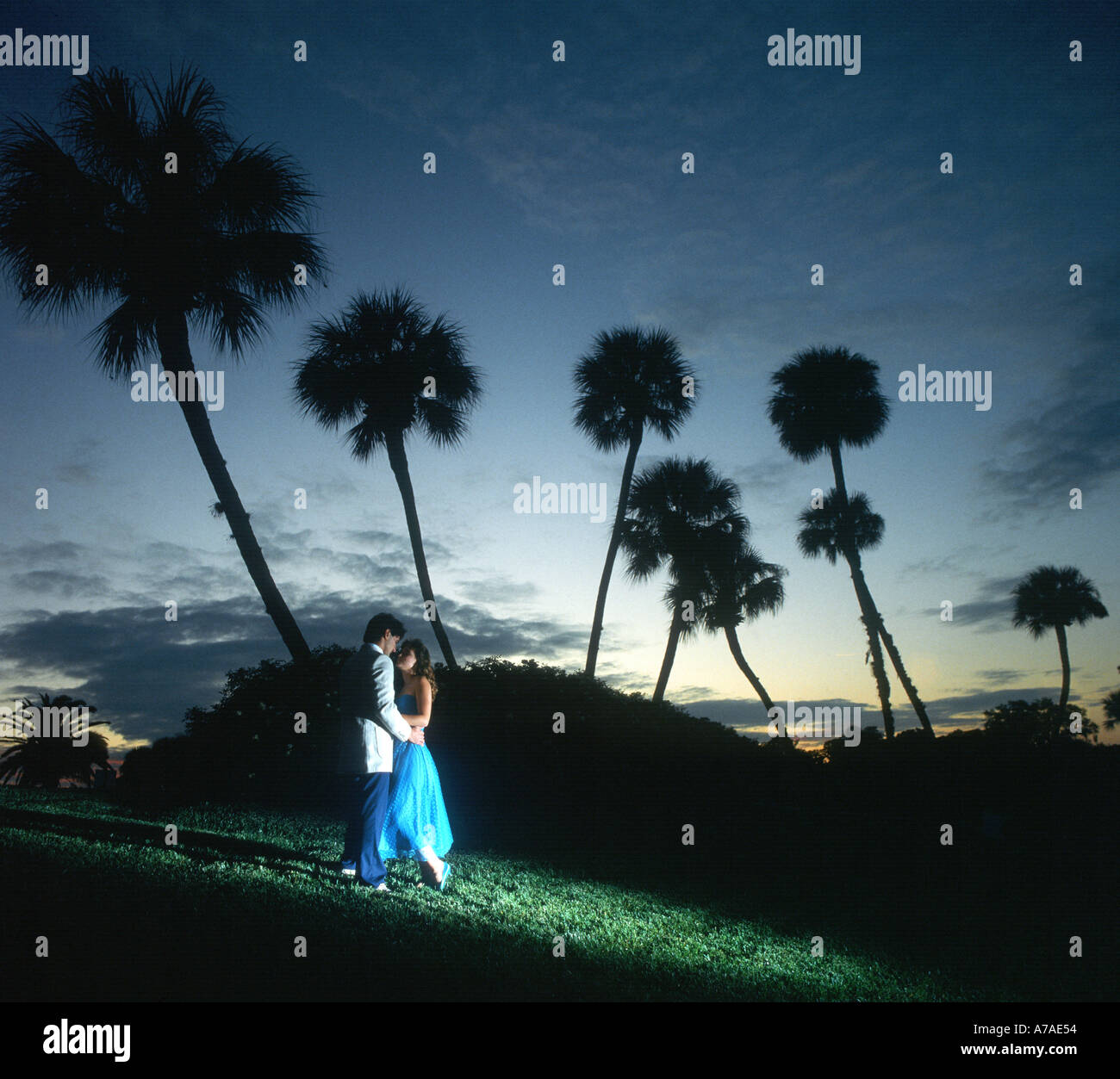 couple embracing on tropical hillside at  night Stock Photo