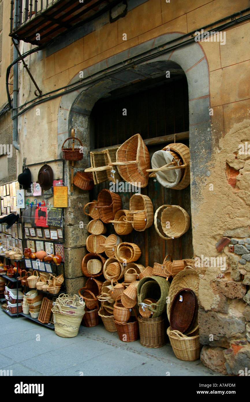 An array of straw baskets and other handmade goods outside one of the gift shops by the cathedral in Segovia, Spain Stock Photo