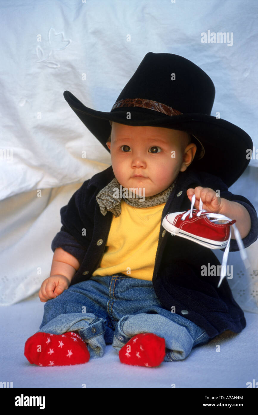 Baby 7-12 month with big cowboy hat and red socks and shoes Stock Photo