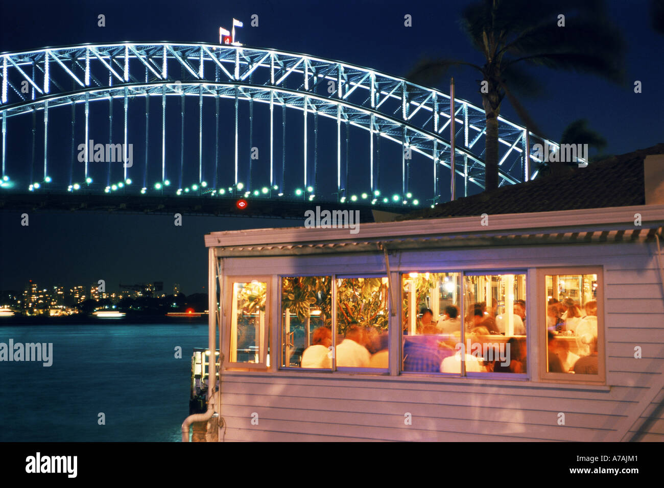 'Sails' restaurant at McMahons Point on Lavender Bay in North Sydney with Harbor Bridge at night Stock Photo