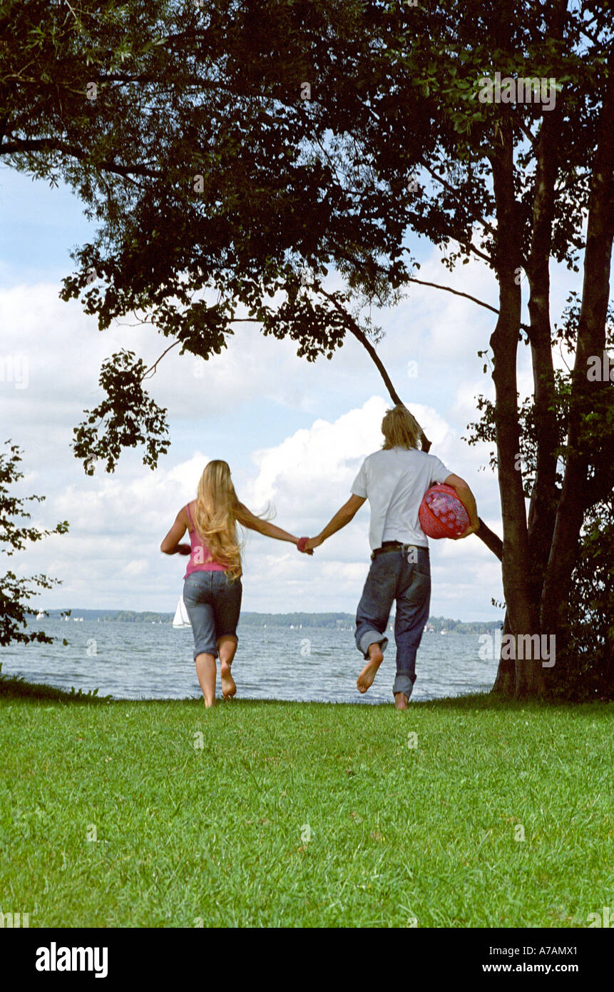 rear view of young couple walking hand in hand Stock Photo - Alamy