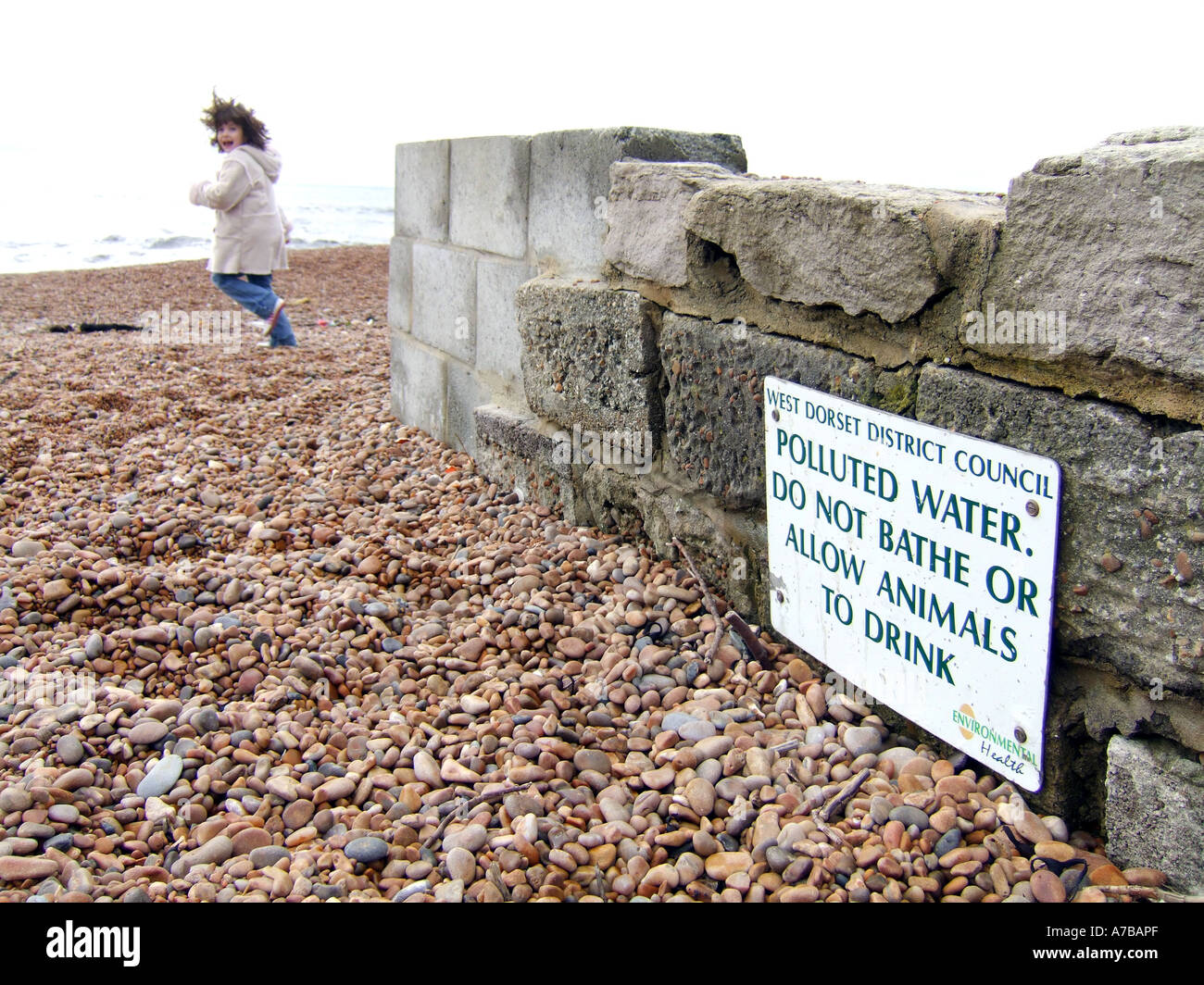 Polluted sea water warning sign at Seatown beach in Dorset Britain UK