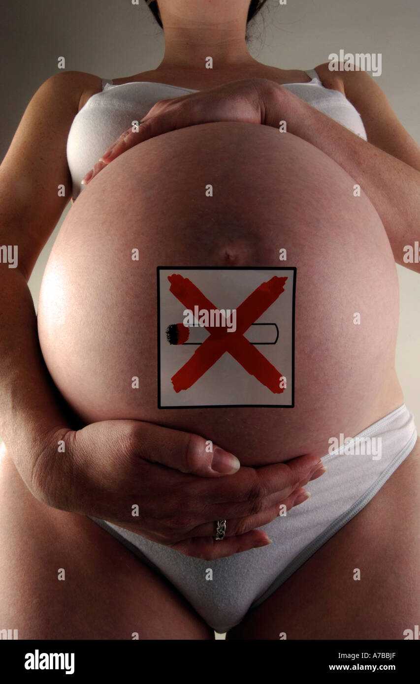 Pregnant Pregnancy woman with no smoking sticker on her stomach Stock Photo