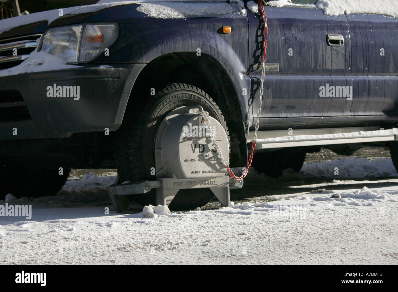 wheel clamp on parked car (SUV) in winter. (c) by uli nusko, ch-3012 bern Stock Photo