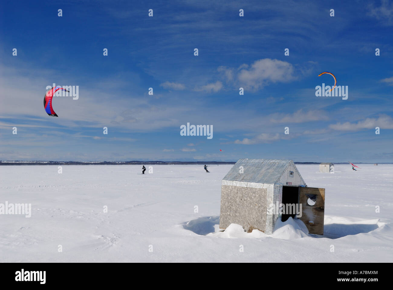 Snowfer and snowkiters with icefishing huts on frozen Lake Simcoe Ontario Canada Stock Photo