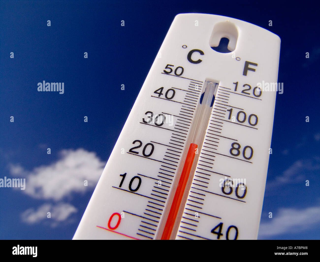 HEATWAVE Temperature rising Concept Thermometer displays a hot and sunny 28 degrees centigrade ( 82F) against a bright blue sky Stock Photo