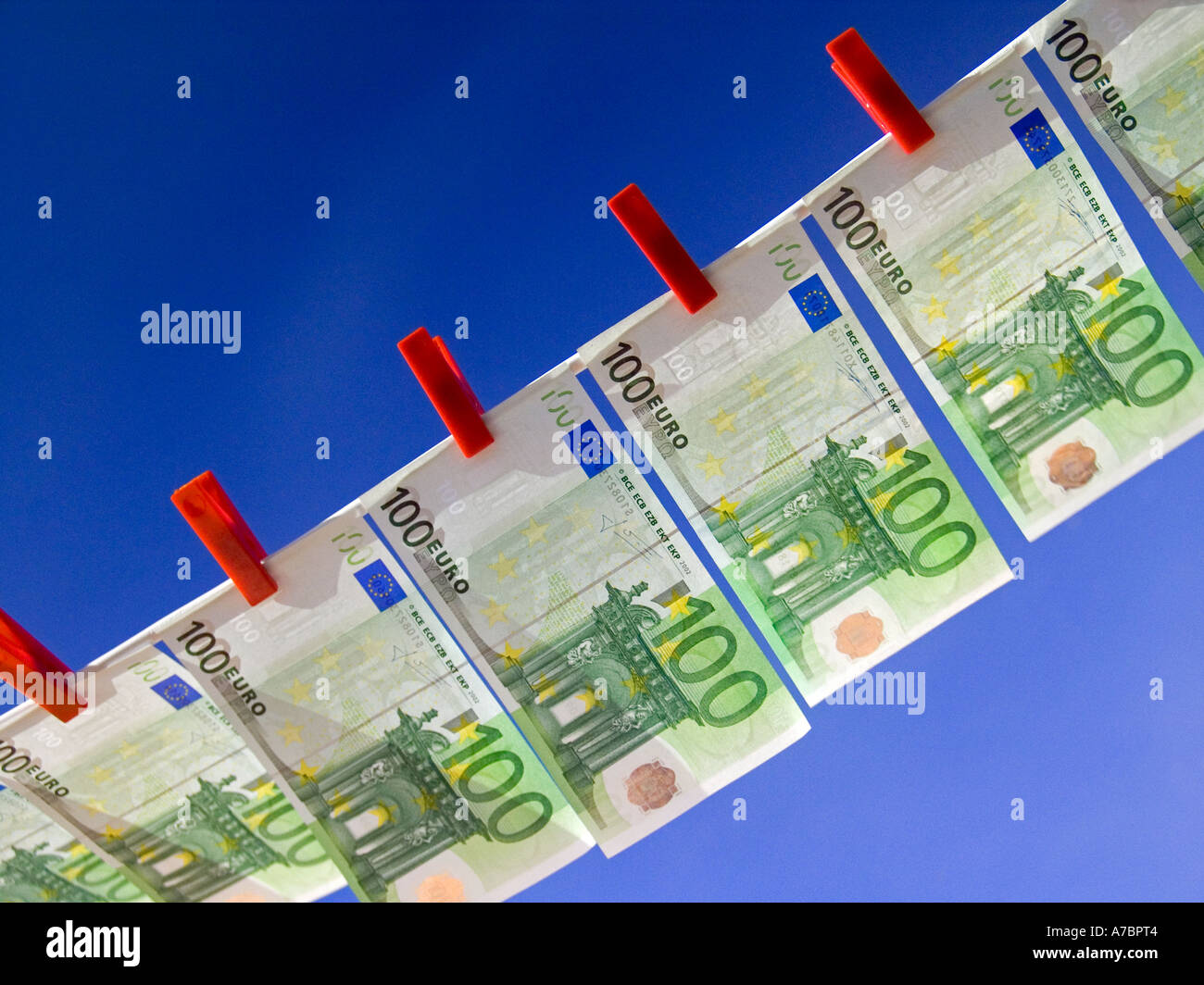 EUROS CONCEPT BLUE SKY Crisp new 100 Euro notes pegged on a washing line against a sunny blue sky Horizontal Landscape Outdoors Exterior Stock Photo