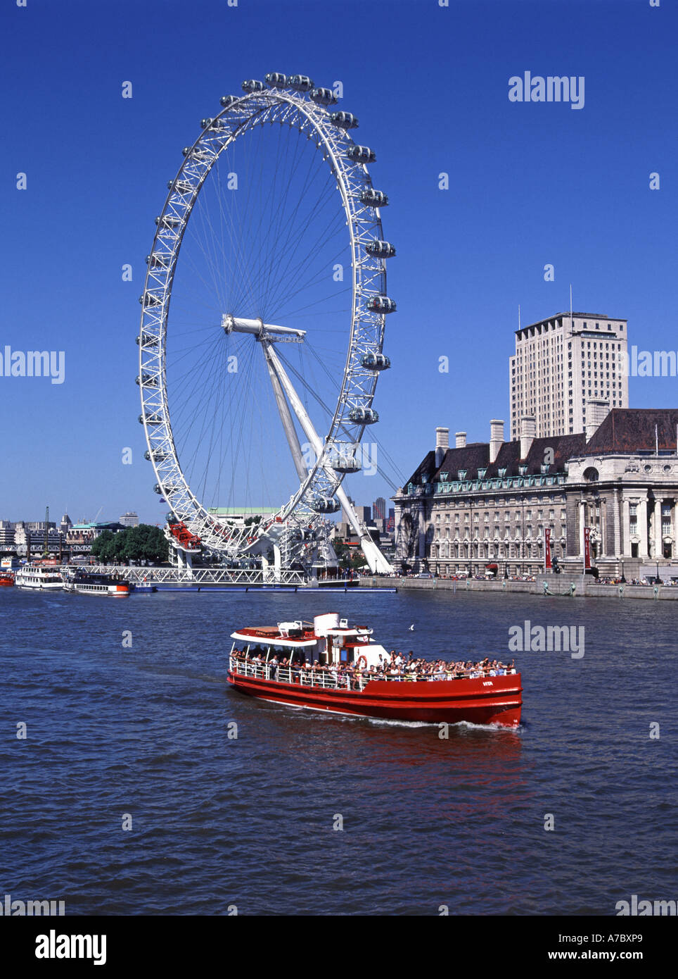 London red river Thames tour boat passing millennium eye Ferris wheel ...