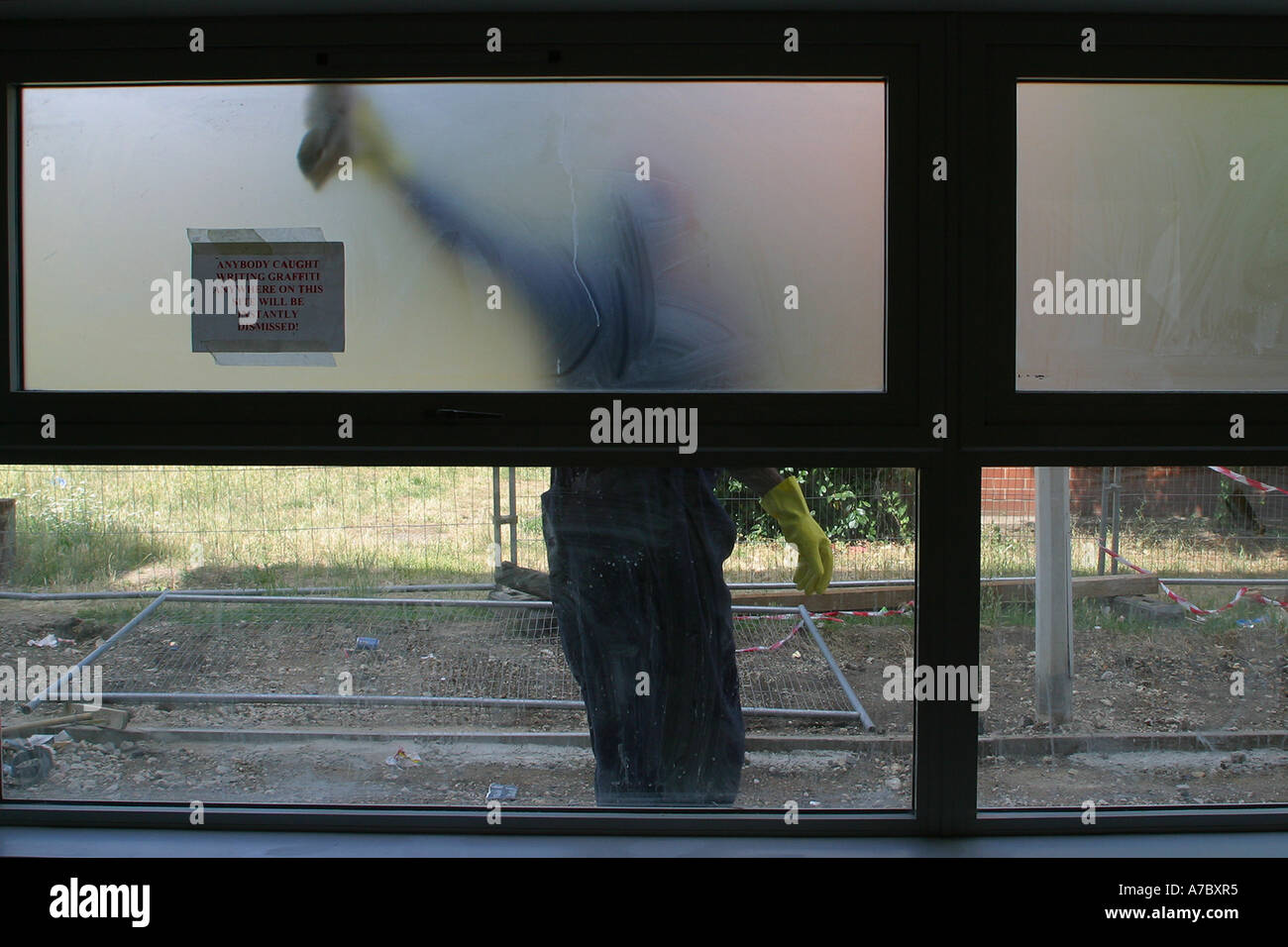 Workman cleaning the window frames outside the nursery Stock Photo