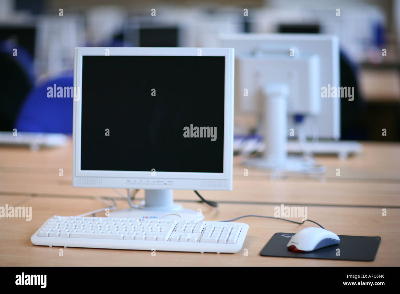 Flat computer monitor screen and mouse in large open plan office, screen  blank. The office is empty Stock Photo - Alamy