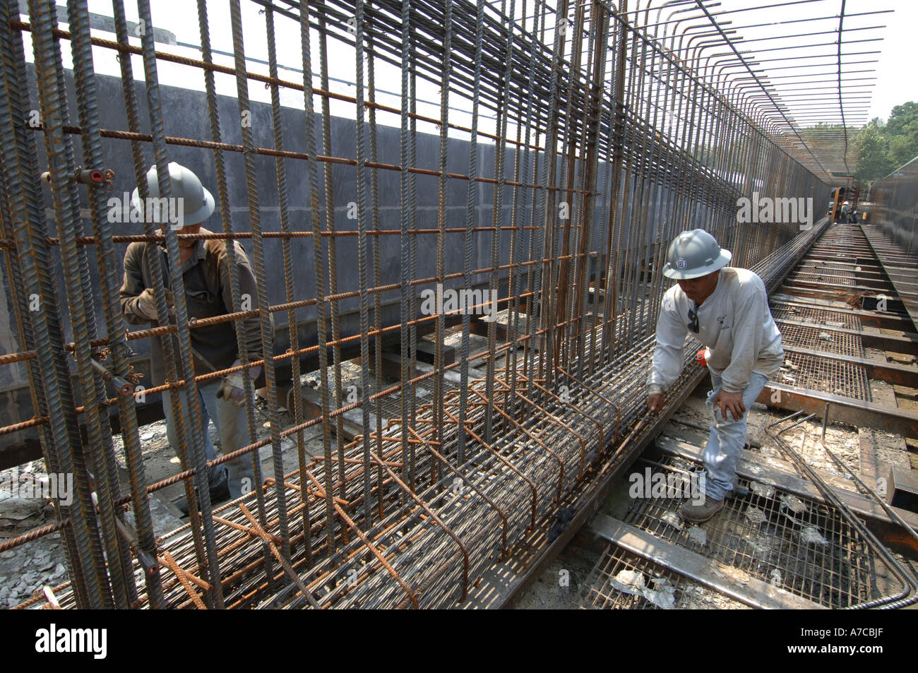 Hispanic workers inspect rebar before large pre stressed concrete girders are poured for new Atlanta airport 2005 Robin Nelson M Stock Photo