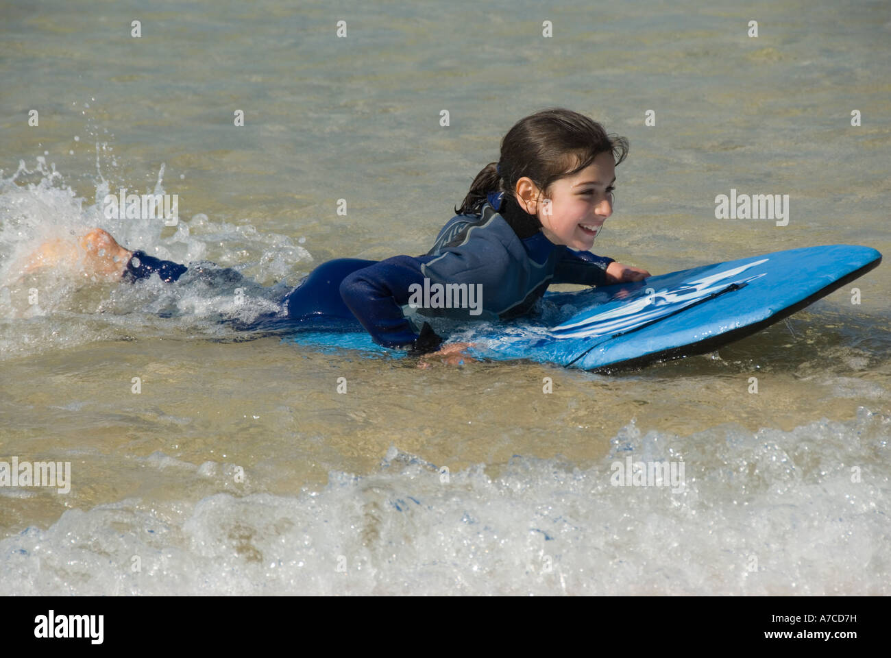 Young girl in wetsuit bodyboarding Stock Photo Alamy