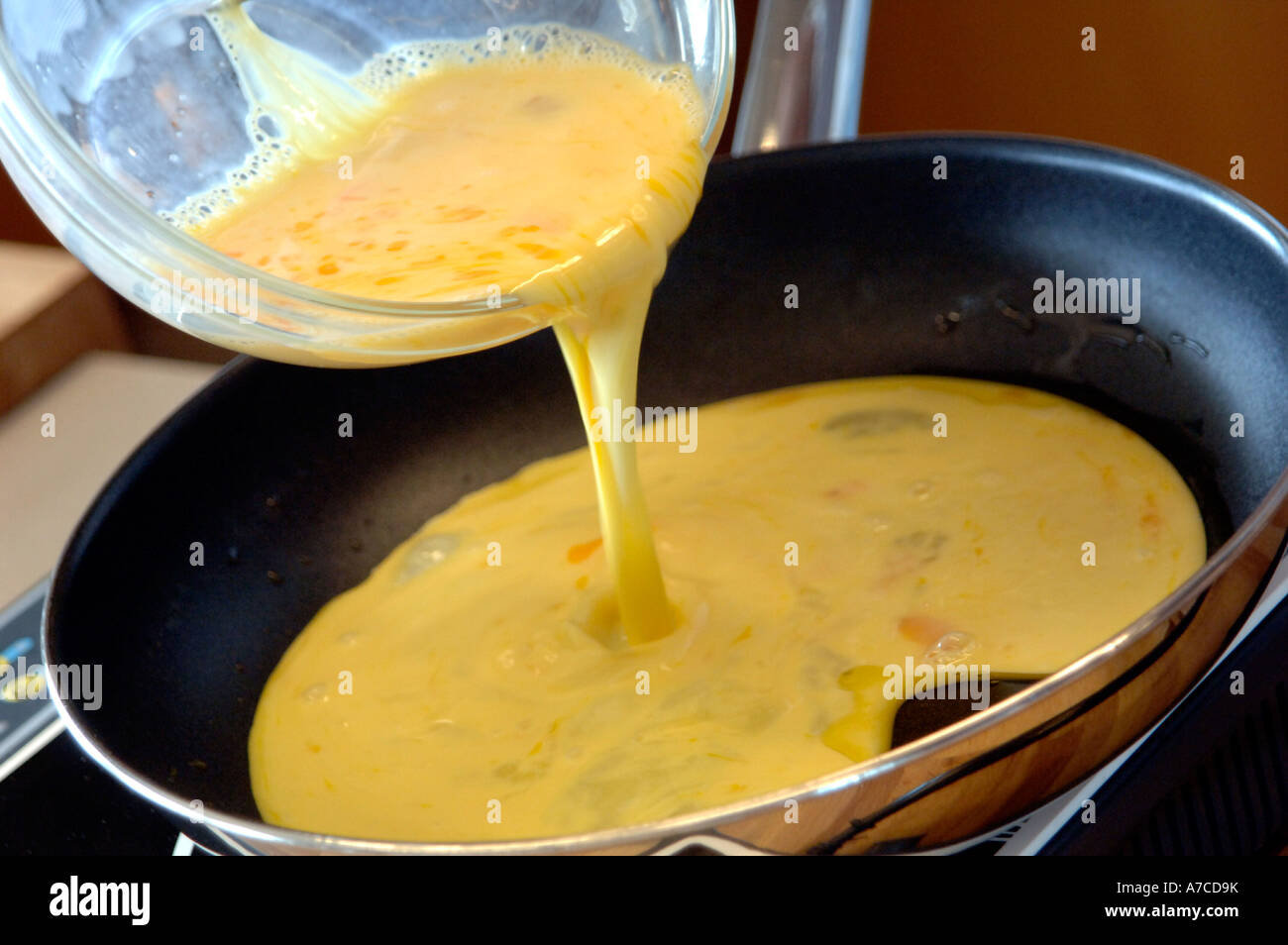 Pouring omelette mix into a frying pan Stock Photo Alamy