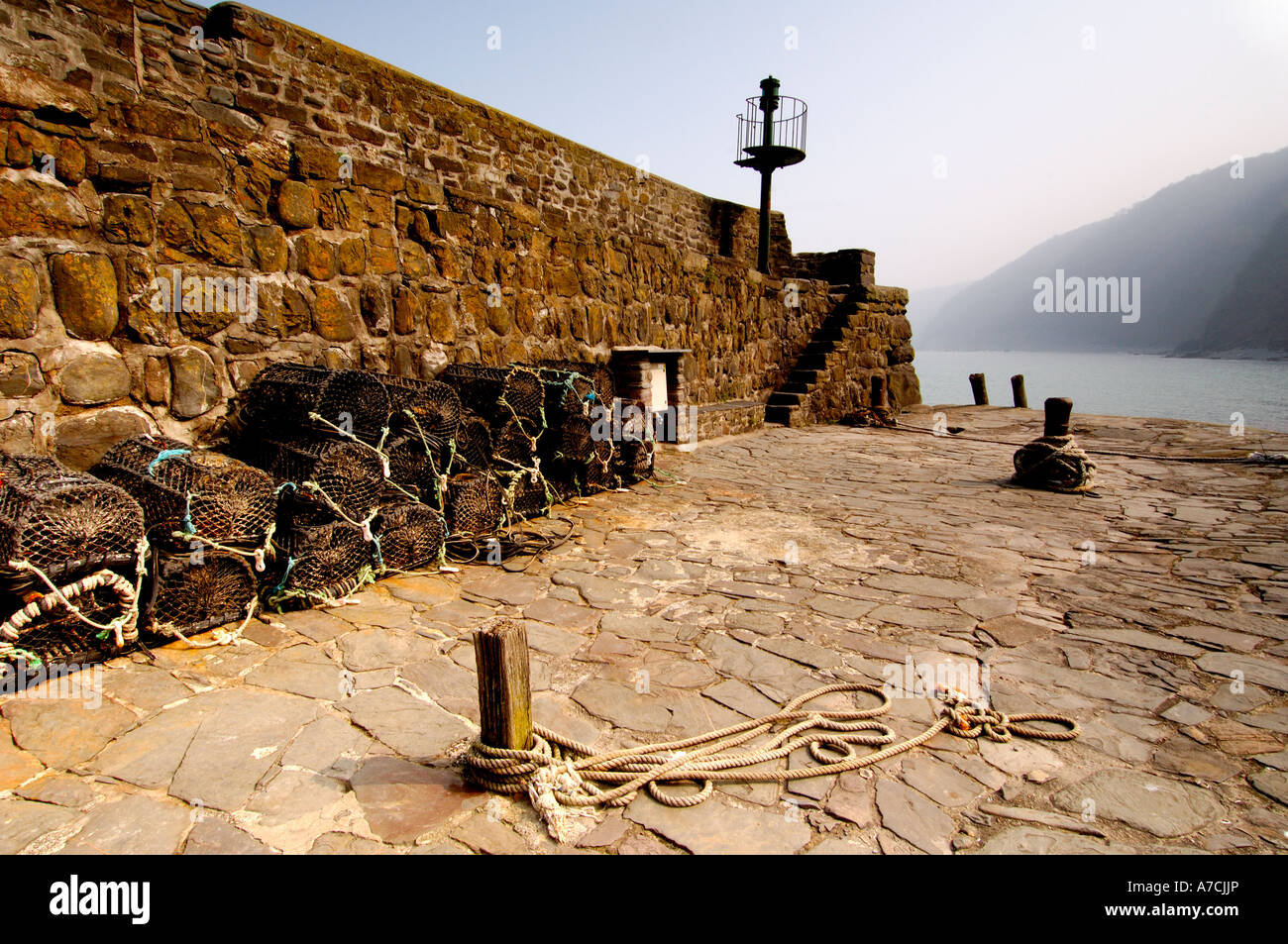 Lobster pots on the end of the historic 14th century stone built harbour at Clovelly North Devon Stock Photo