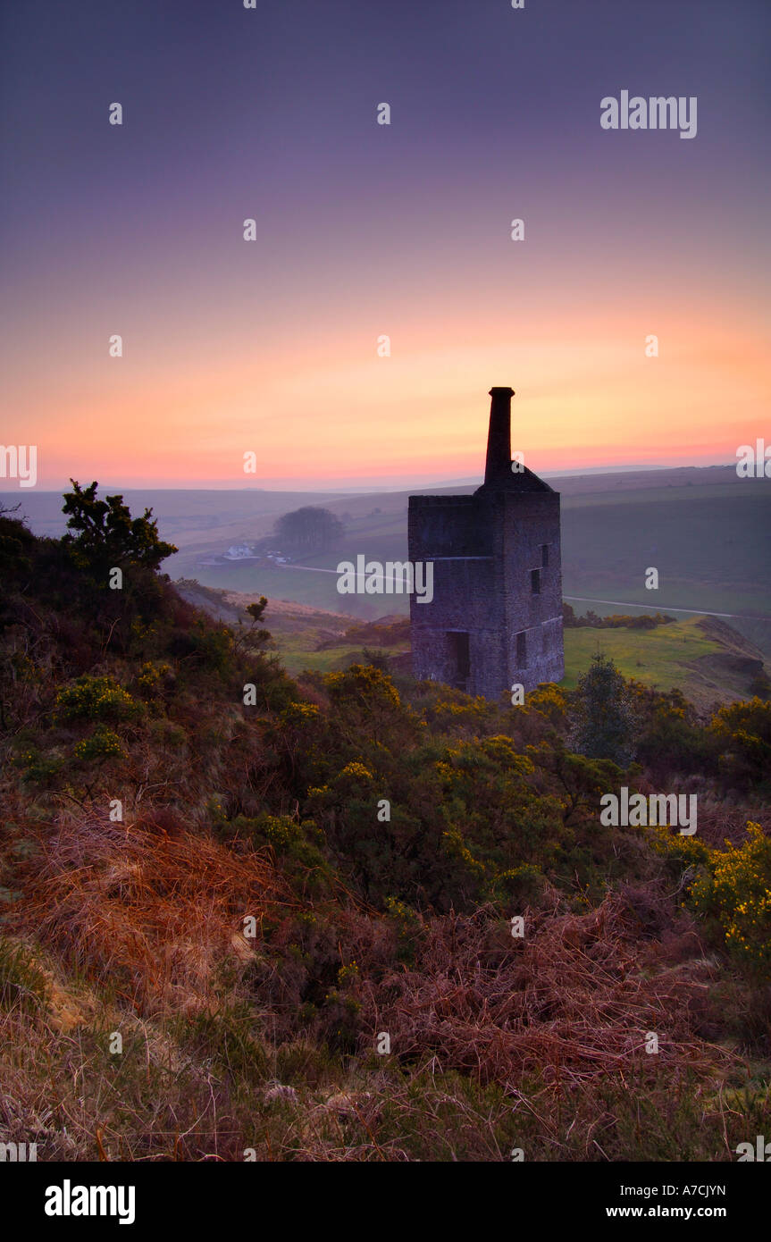 Derelict mine engine Wheal Betsy near Tavistock with the orange glow of pre dawn in the sky and a little distant mist Stock Photo