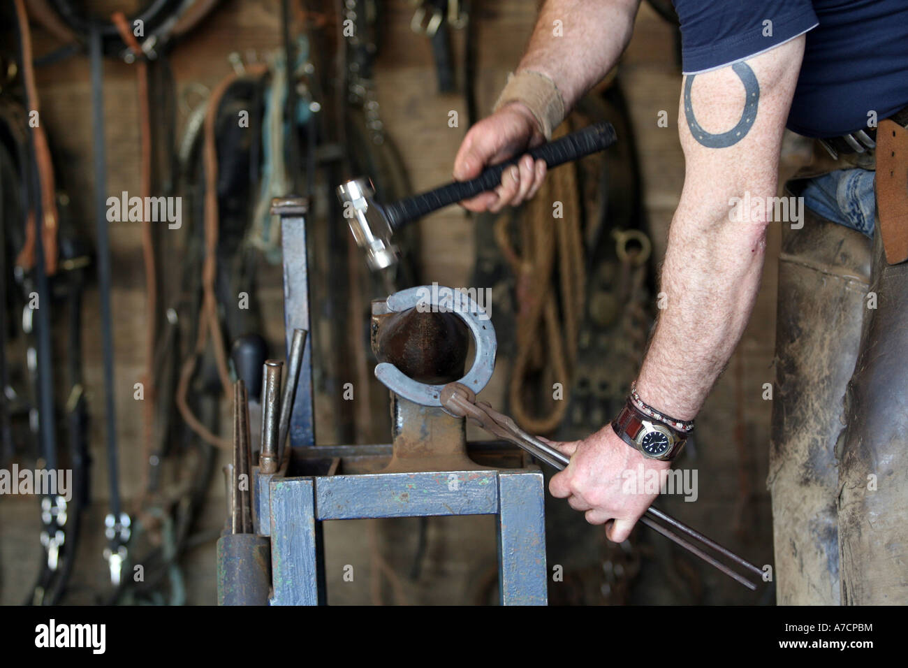 Blacksmith working with old fashioned traditional tools on horse shoes