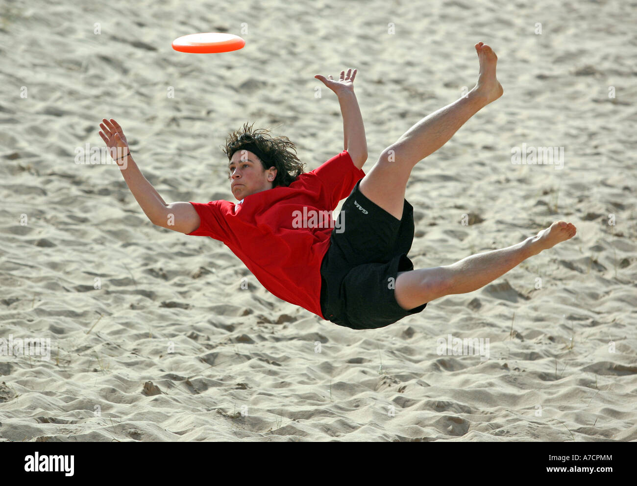 man in mid air takes part in extreme sport of ultimate frisbee at Balmedie beach, Aberdeen, Aberdeenshire, UK. Stock Photo