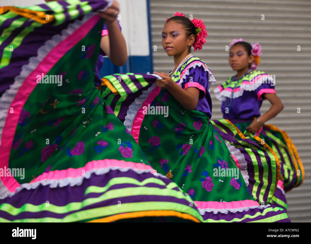 Three attractive local young girl folk dancers perform with swirling ...