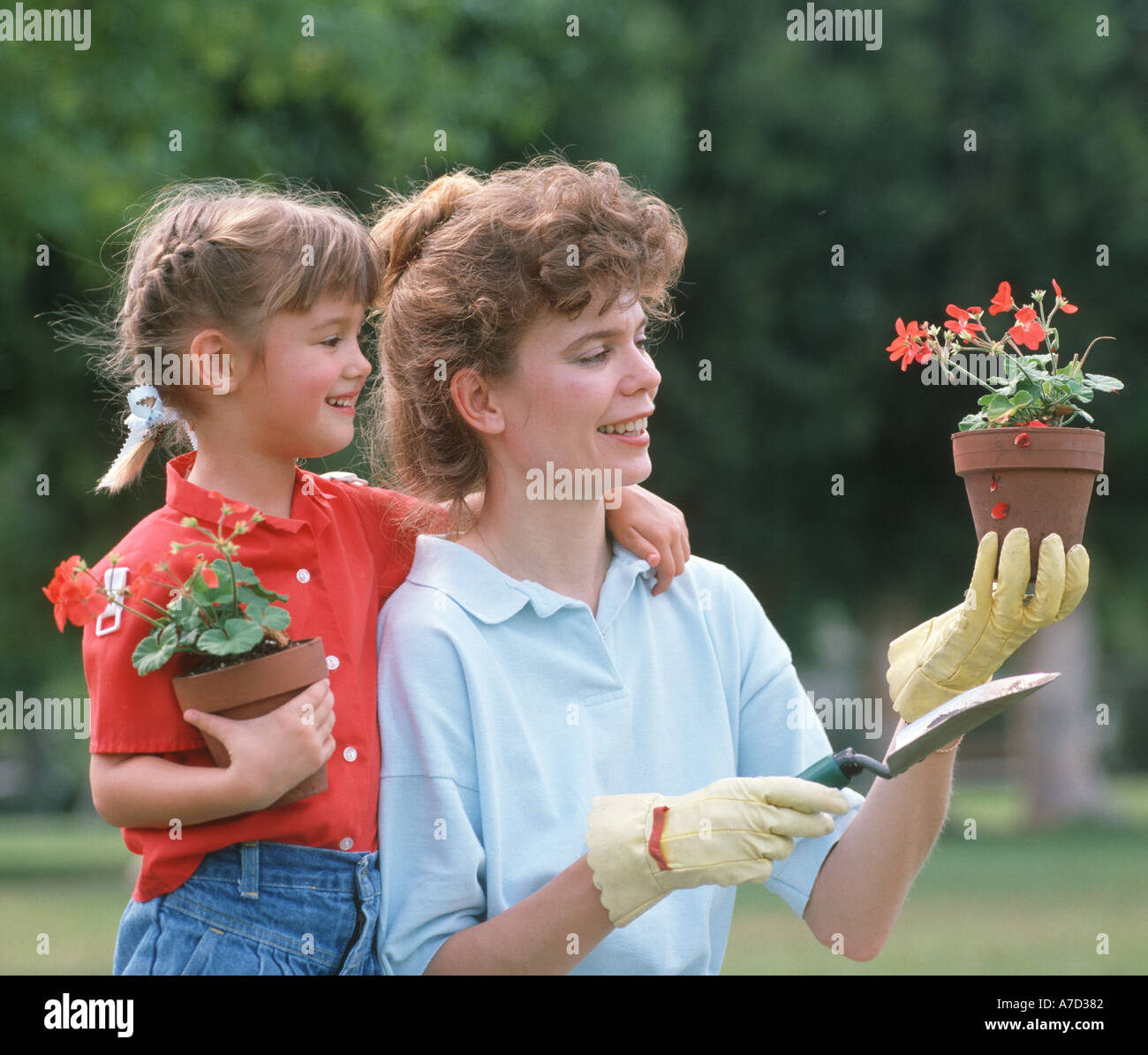 mother and daughter planting flowers Stock Photo