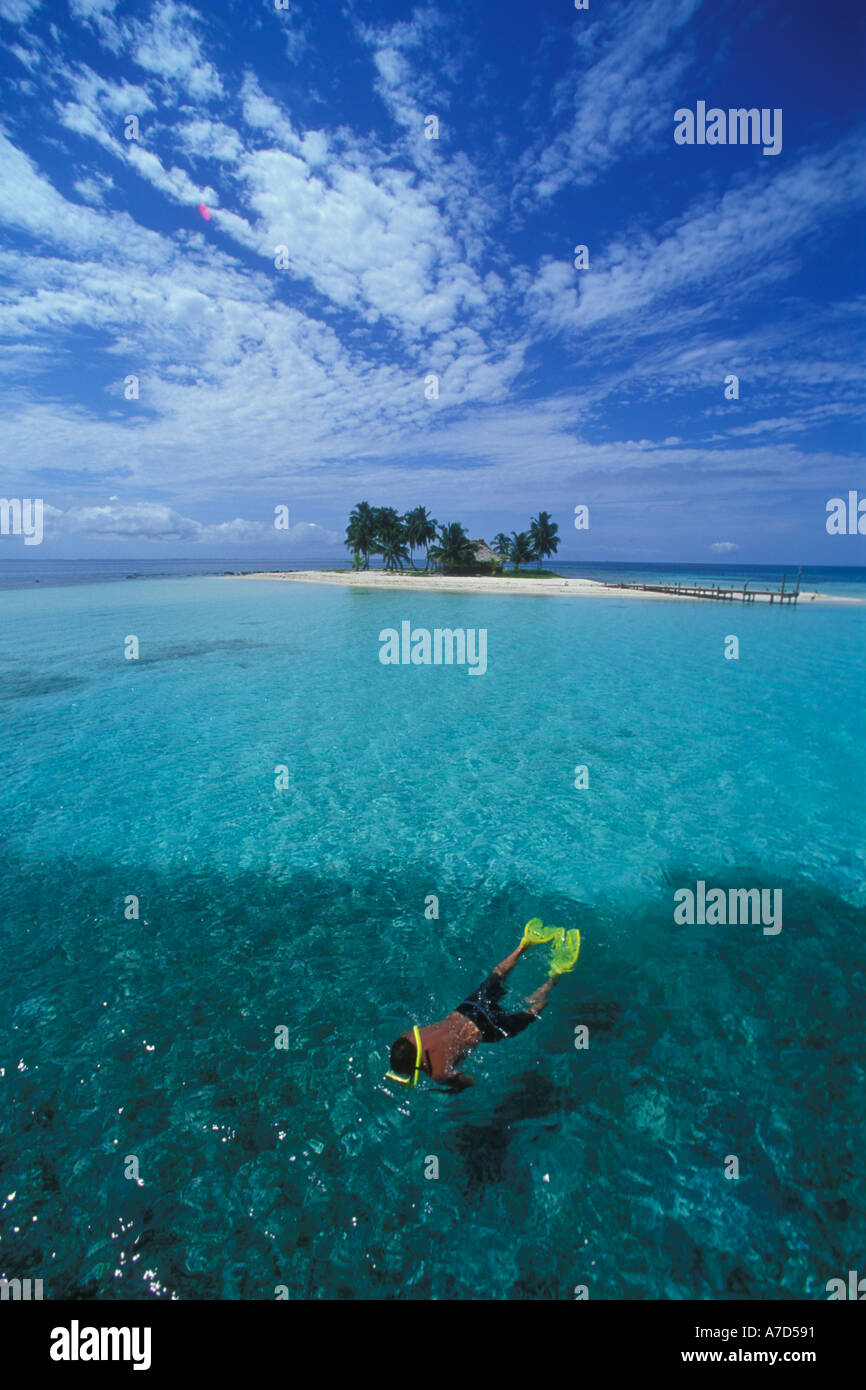 A SMALL TROPICAL ISLAND IN BELIZE IS THE BACKGROUND FOR A MALE SNORKELER Stock Photo