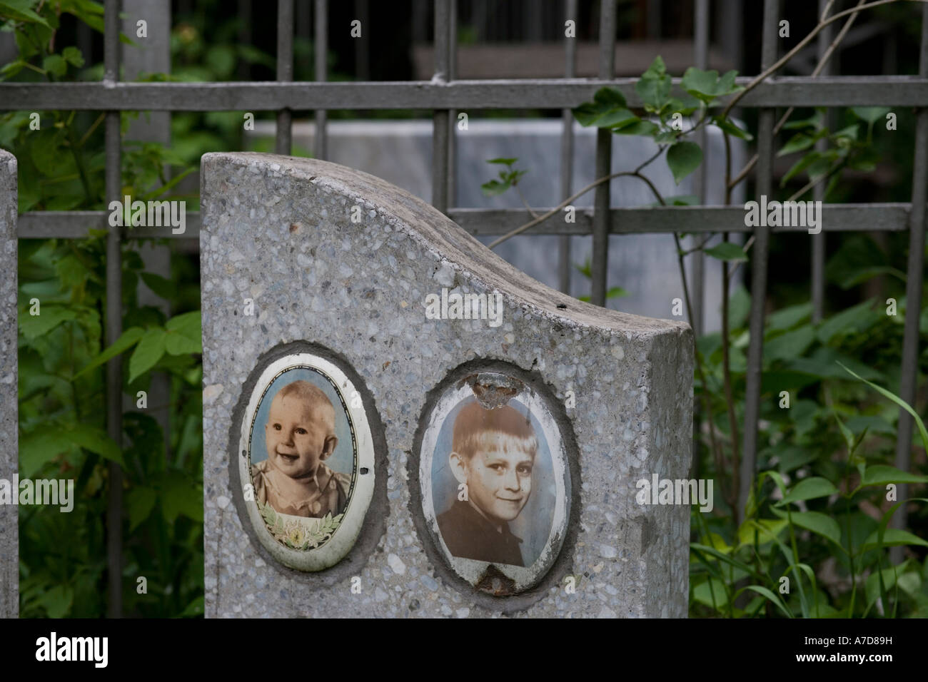 Two enameled portrait photos on headstone of children's grave in graveyard Almaty Kazakhstan Stock Photo