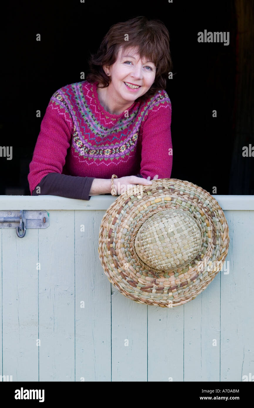 Anna Lewington with hat made from rushes harvested in a traditional and sustainable way from the River Stour in Dorset, England Stock Photo