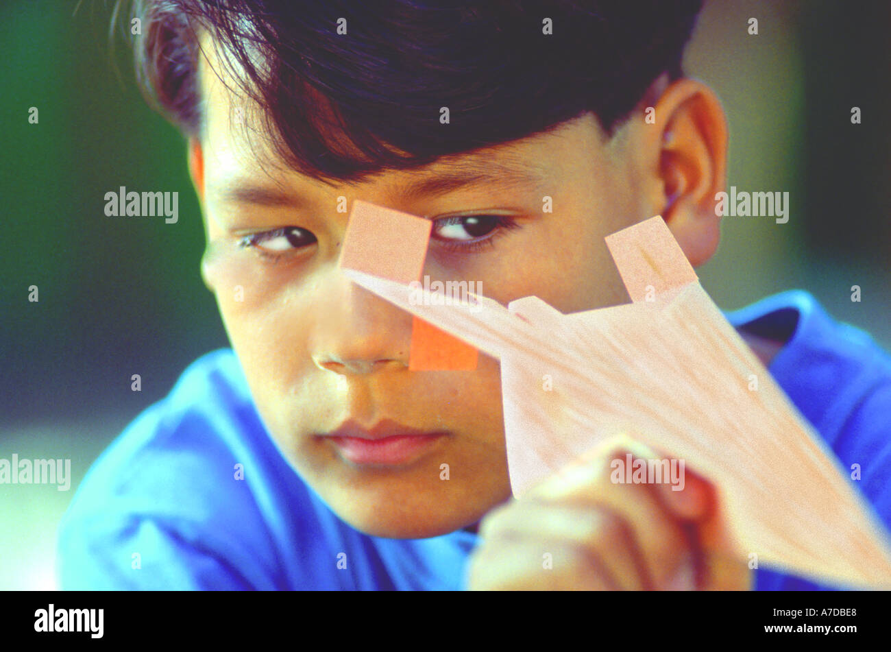 Asian American boy aiming paper airplane Stock Photo