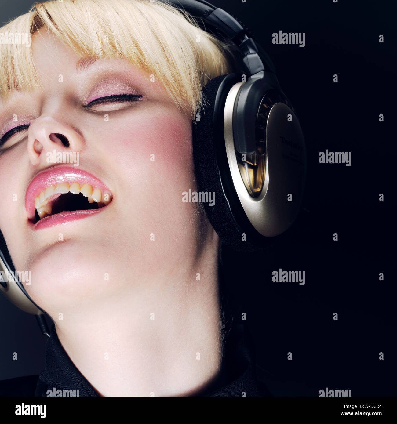 BLONDE EYES CLOSED WITH HEADPHONES Stock Photo