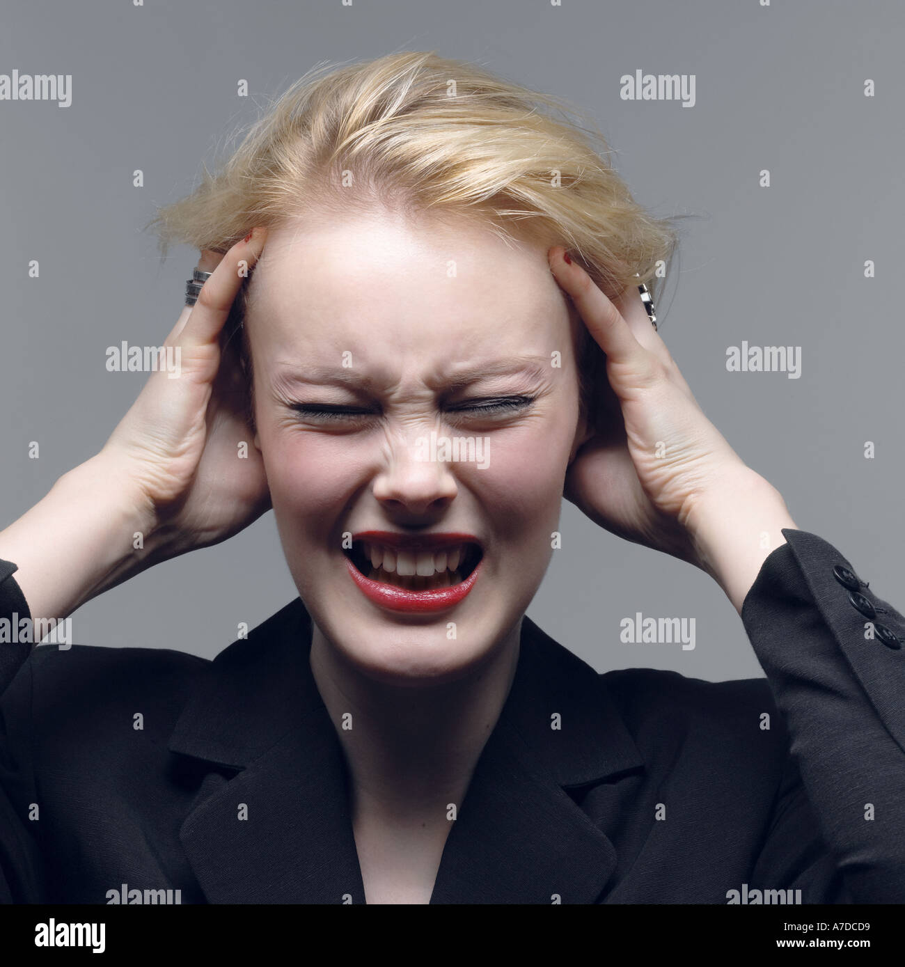 young stressed business woman with hands to her head in despair Stock Photo