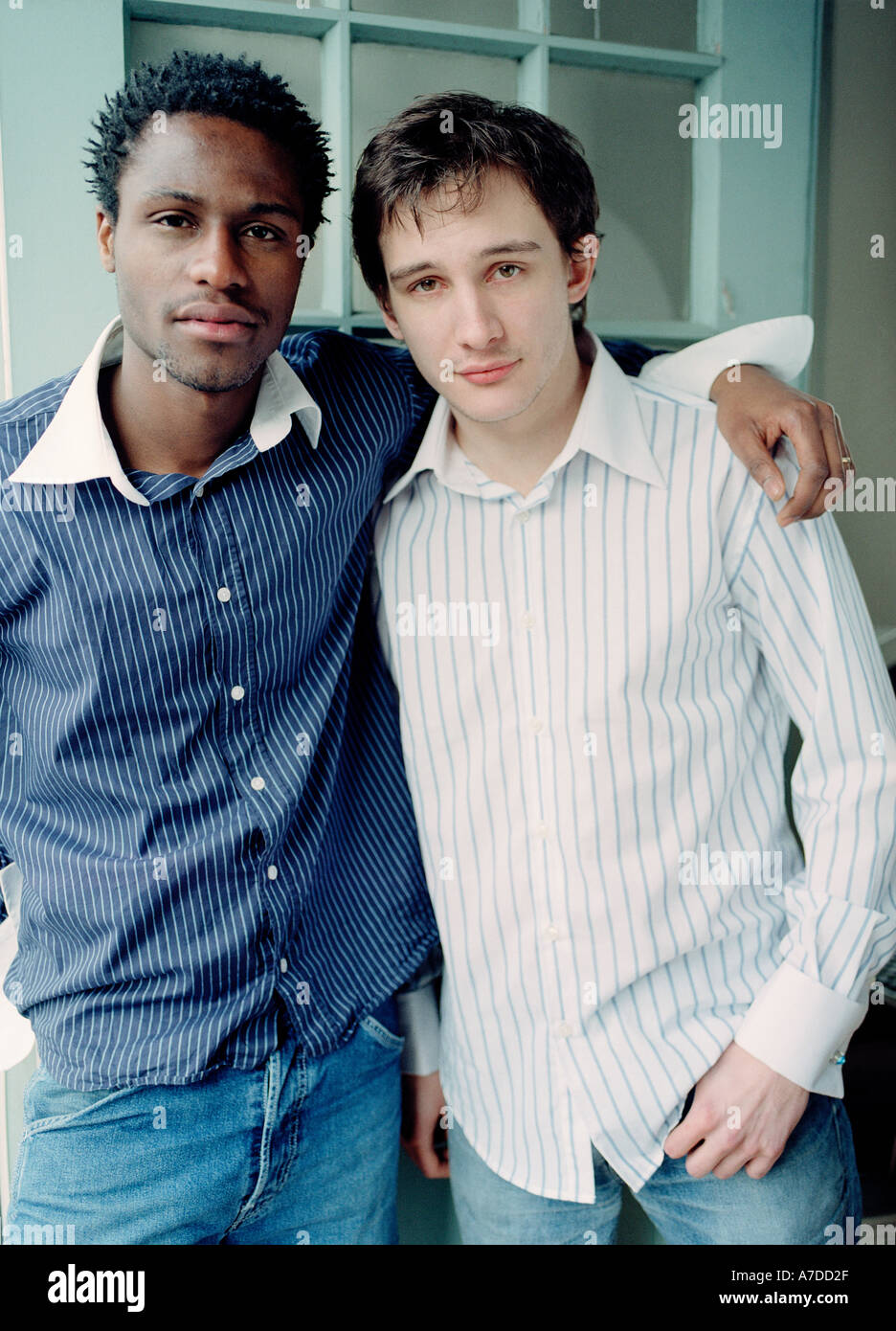 Portrait of young men one with arm around the other Stock Photo