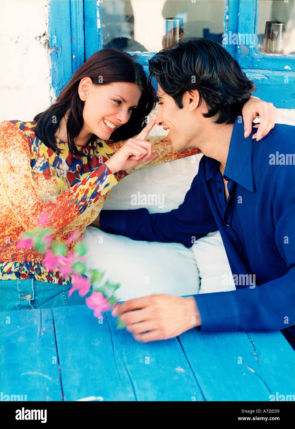 couple sitting at blue table outdoors Stock Photo