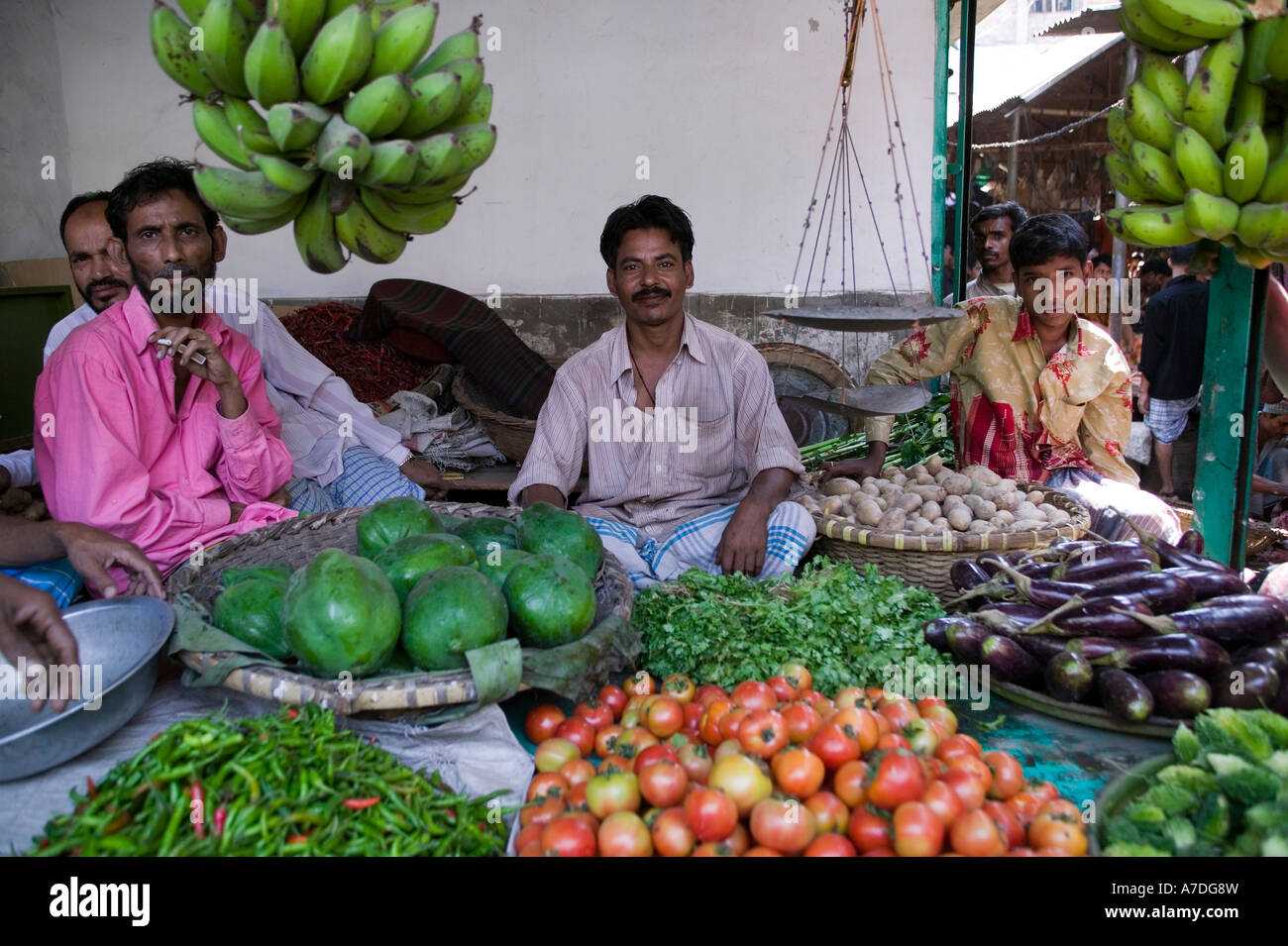 Men share a vegetable stall at an outdoor market in Dhaka Bangladesh Stock Photo