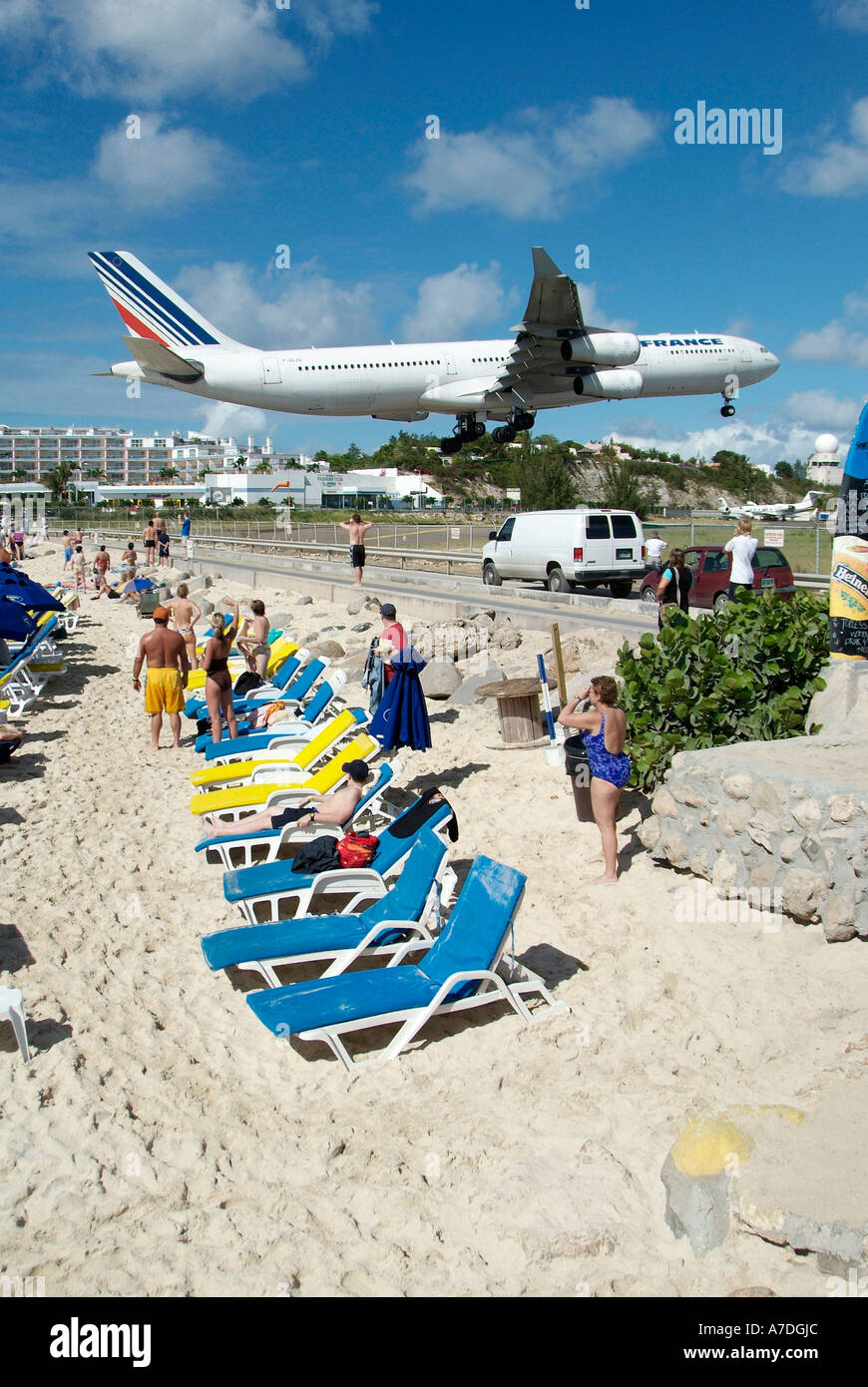 Air planes land at runway which ends at the Sun Beach on the Caribbean Island of St Maarten Martin in the West Indies Stock Photo