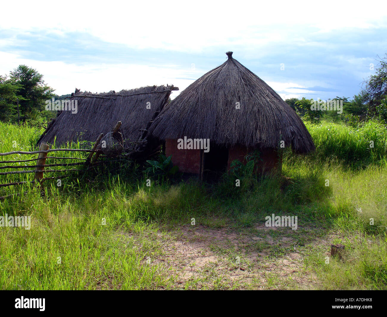 Traditional African village house with thatched roof with green field in Copperbelt region of Zambia Stock Photo